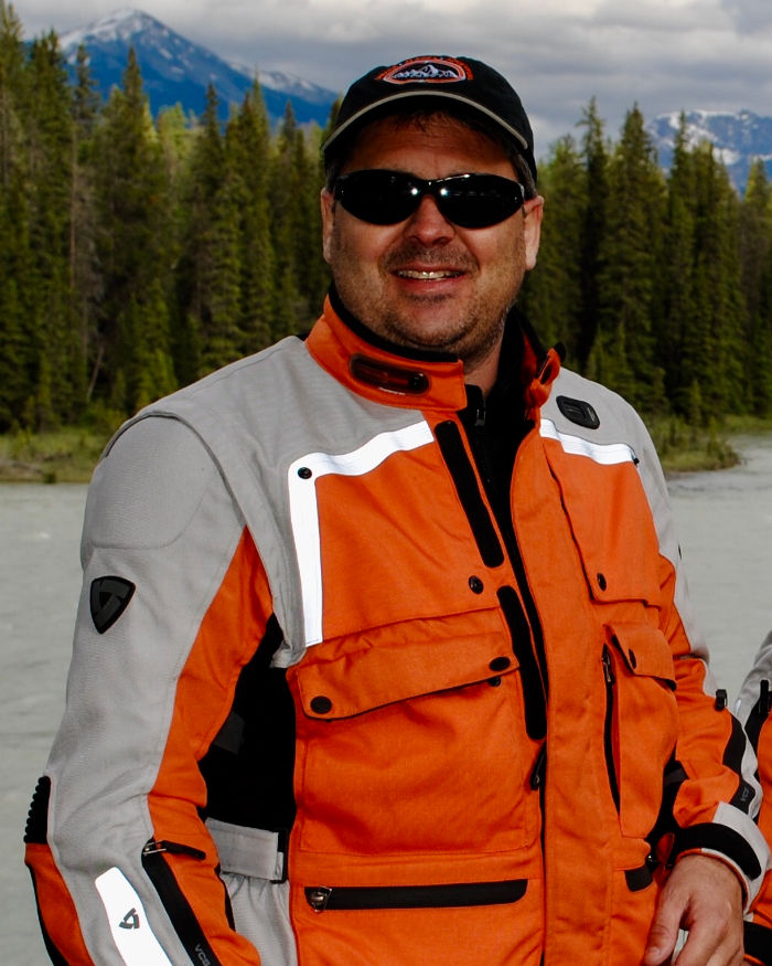Mark Girardi in orange motorcycle jacket